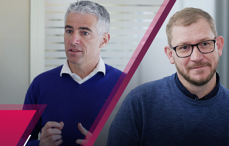 two men positioned side by side facing the camera both in a office enviroment